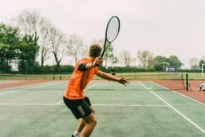 joueur en vêtements de tennis orange et noir