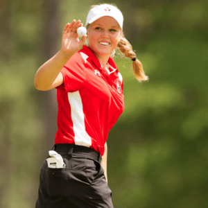 femme souriante portant un polo de golf rouge