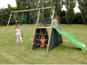 3 enfants sur aire de jeux avec toboggan