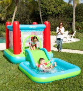 2 enfants dans un chateau gonflable avec piscine