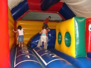 3 enfants dans un grand chateau gonflable