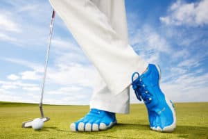 pieds croisés avec des chaussures de golf colorées