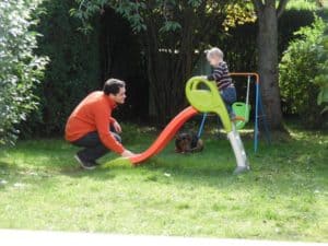 enfant jouant au toboggan avec son papa