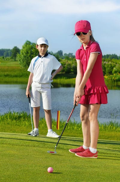 Fille et garçon en tenue de golf