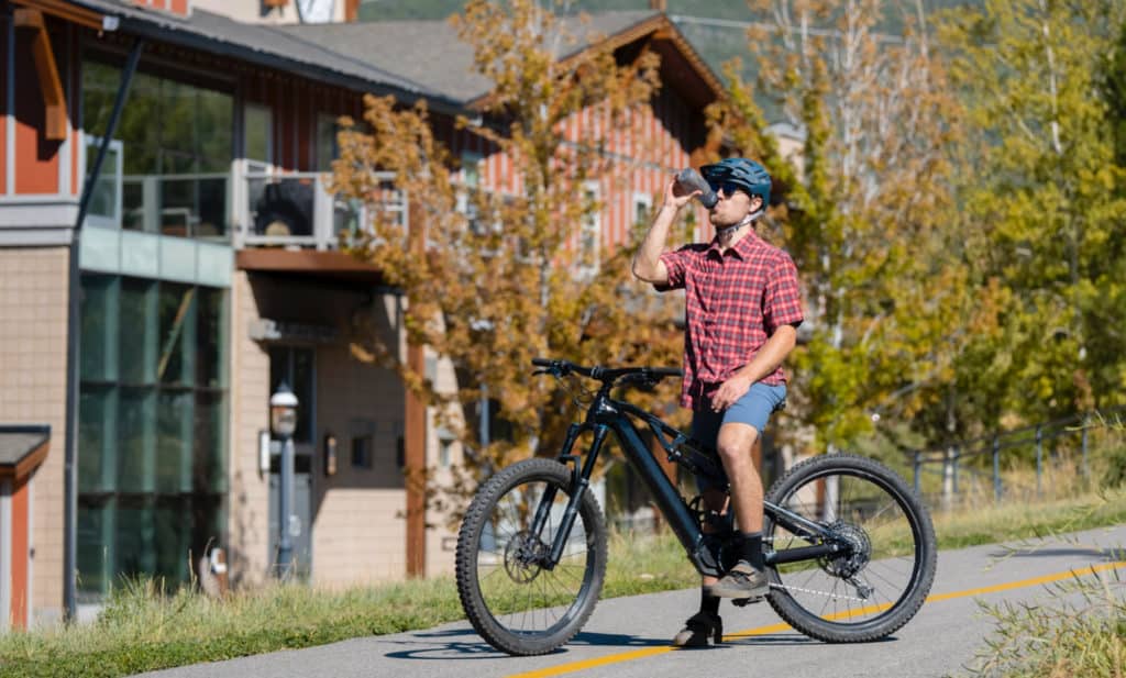 homme qui pratique le vélo électrique en buvant dans sa gourde