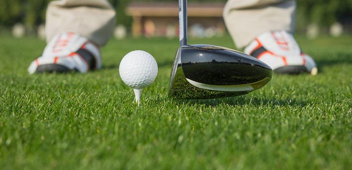 club de golf type bois prêt a frapper la balle de golf sur l'herbe