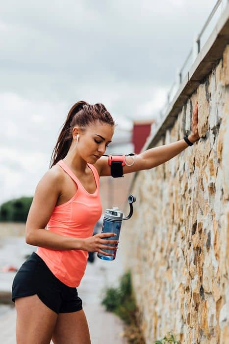 femme sportive qui tient sa boisson enrichie en protéines alimentaires et en vitamines