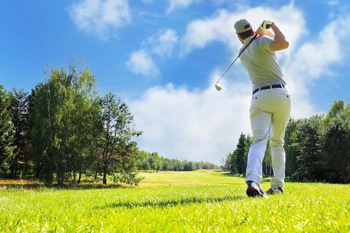 joueur de golf qui frappe la balle avec un fer adapté